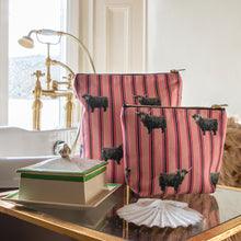 Load image into Gallery viewer, Pink Billy Coo matching toiletry bags sitting beside a vintage rolltop bath